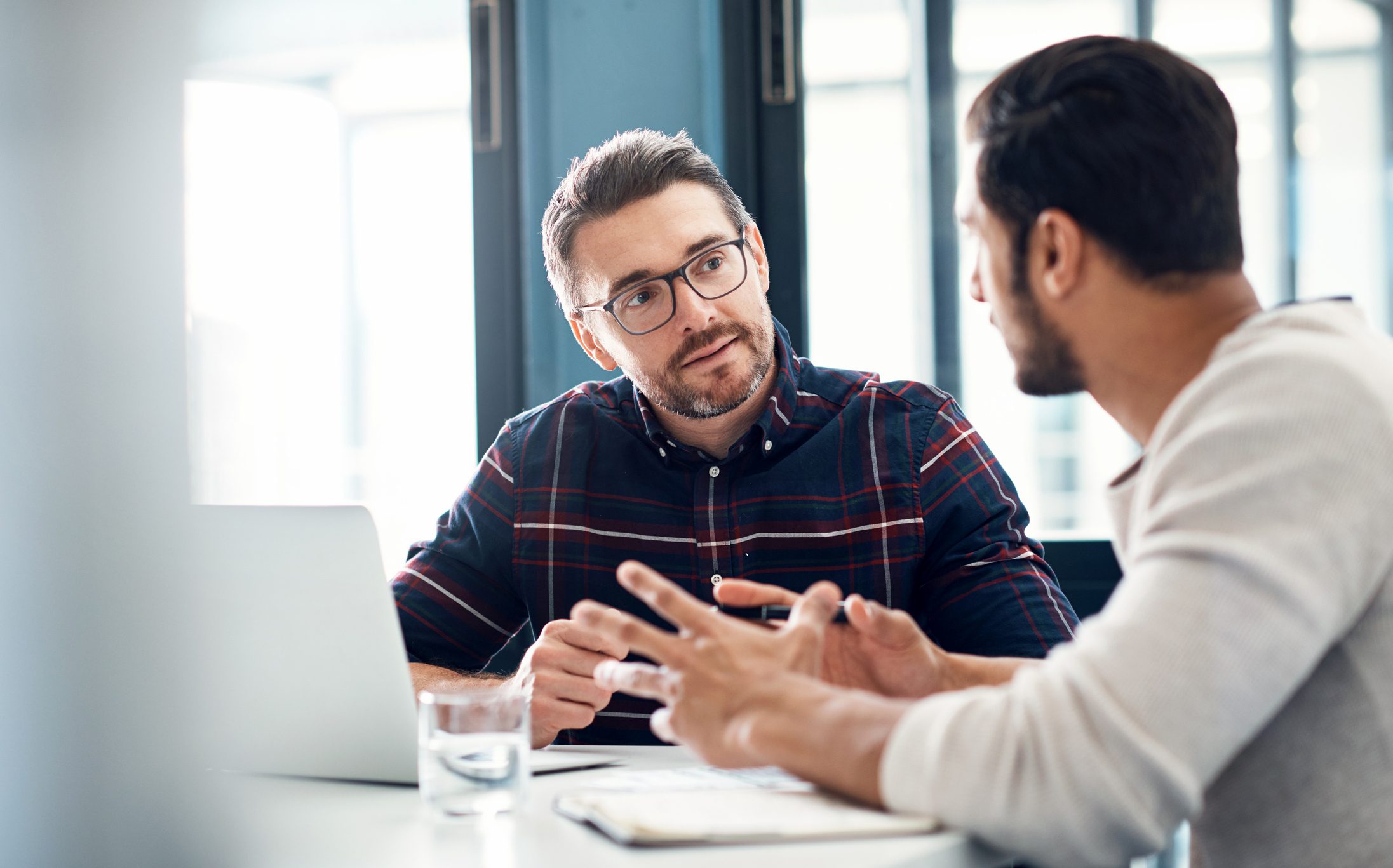 Two men in business meeting with laptop and notepad